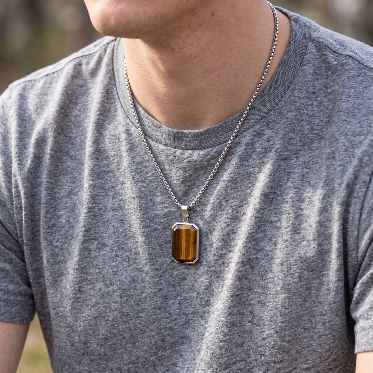 Tiger eye necklace worn over a grey t-shirt