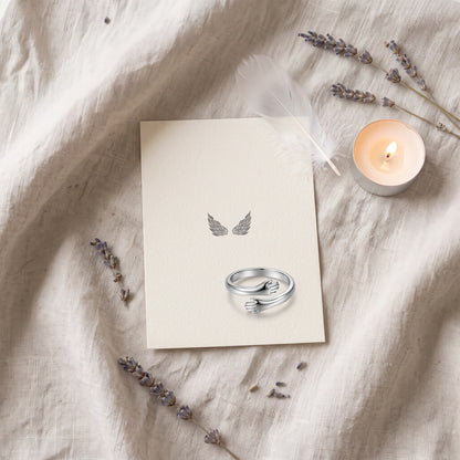 Hug ring on an angel wings card with a candle